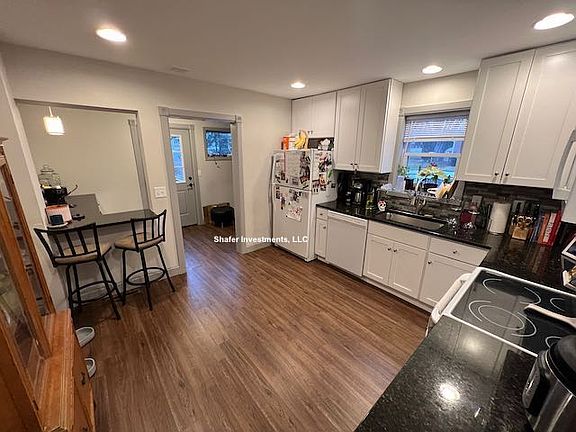 This photo showcases the kitchen with new cabinets, granite countertops, and appliances.