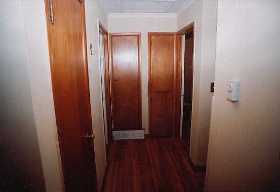 Hall leading to bathroom and two bedrooms. Hall has lots of storage.