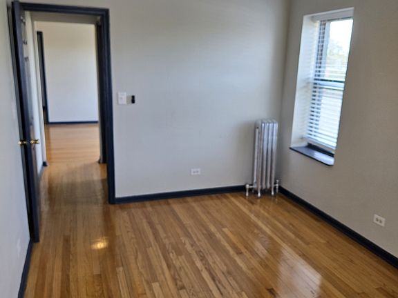 Large primary bedroom with beautiful hardwood floors, ceiling fan...