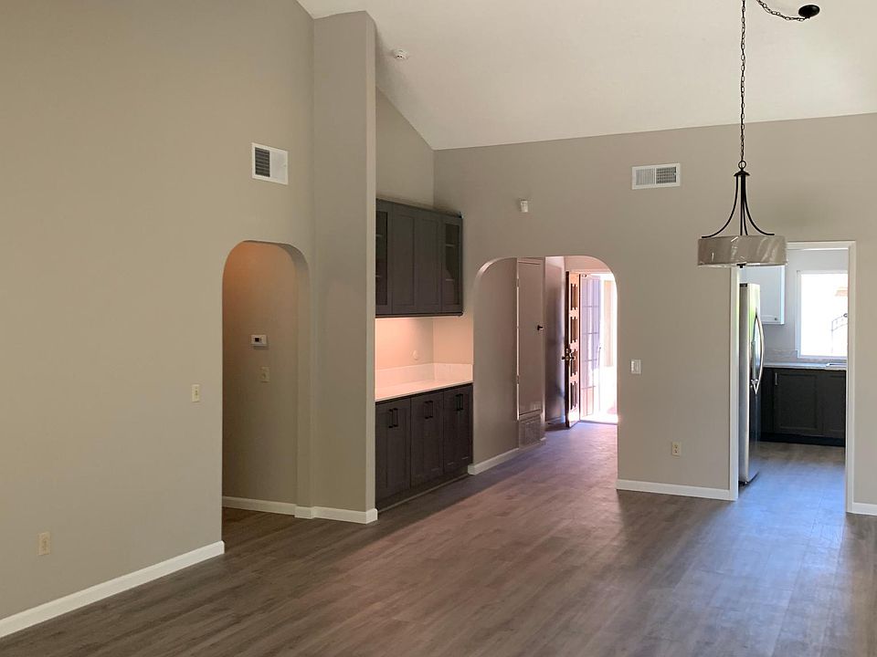 From the living room looking at the dining room, a view of the kitchen and the front door.
