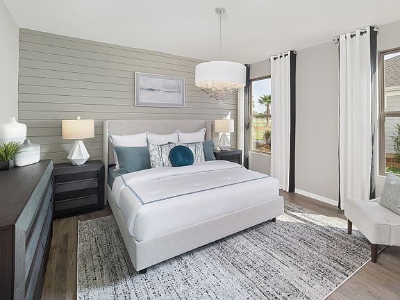 Owner s Suite with shiplap accent wall and windows that allow ample light to flow in