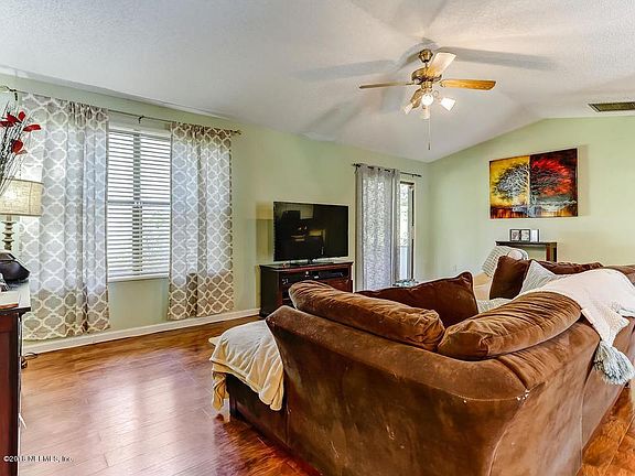Looking into living room from front door hallway, sliding glass door far corner