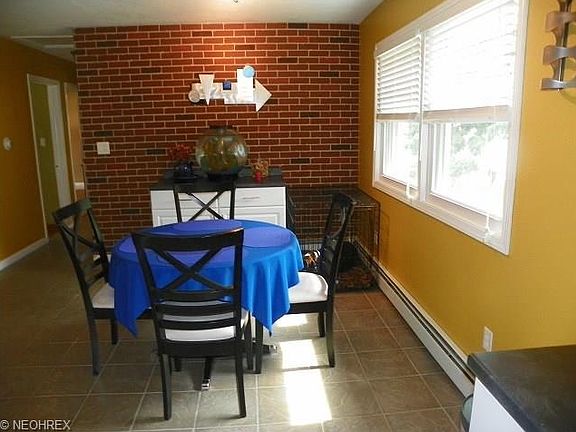Bright ceramic tiled dining room with brick accent wall