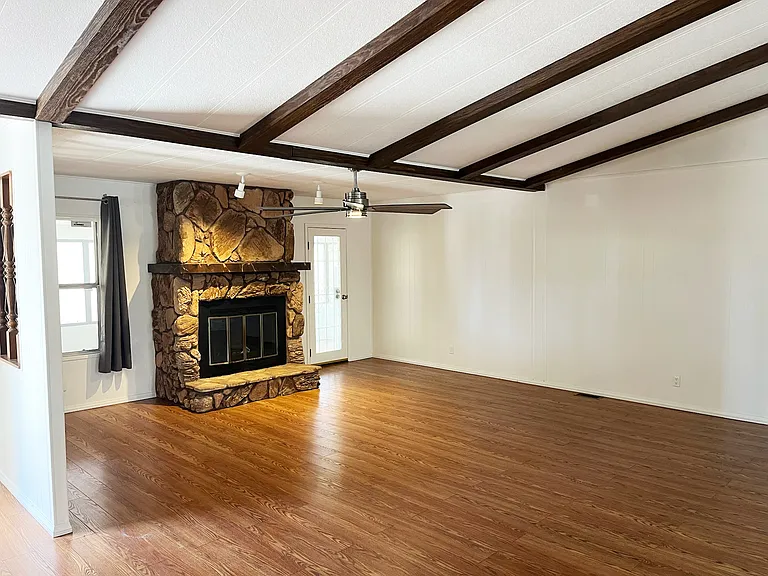 Living area has high ceilings and a ceiling fan with overhead lighting.