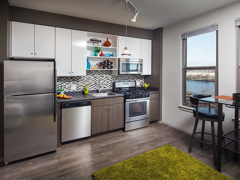 Classic Package II kitchen with stainless steel appliances, dark laminate countertops, white and brown cabinetry, tile backsplash, and hard surface flooring