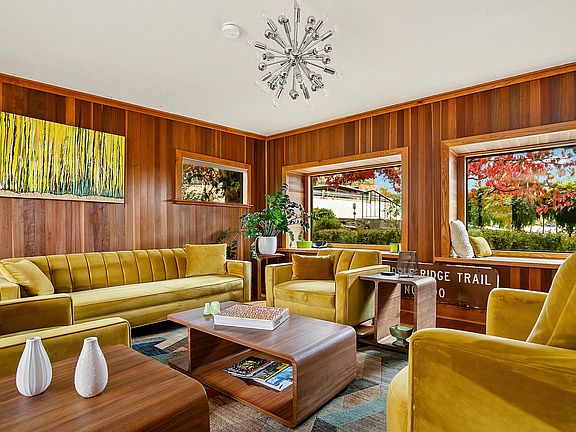 Formal living room with large windows and velvet couches.