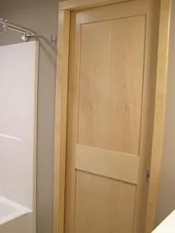 Bathroom maple trim and maple pocket door.