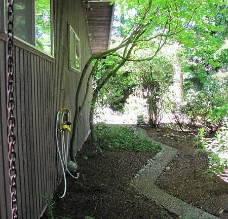 East side view. Walking path to back yard paradise.