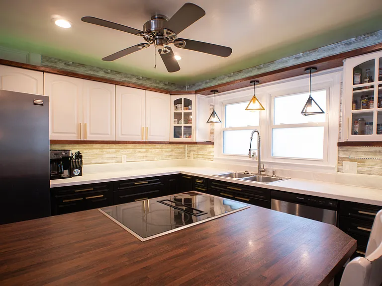 Custom kitchen with oversized island. Kitchen includes ample lighting, automatic dustpans (for easy sweeping - connected to central vac) dishwasher, garbage disposal, wall oven, wall microwave, and electric downdraft cooktop.