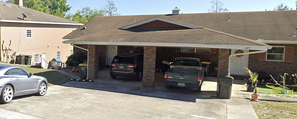 Outside photo of quadruplex. Parking space is seen by car located on left (uncovered space).
