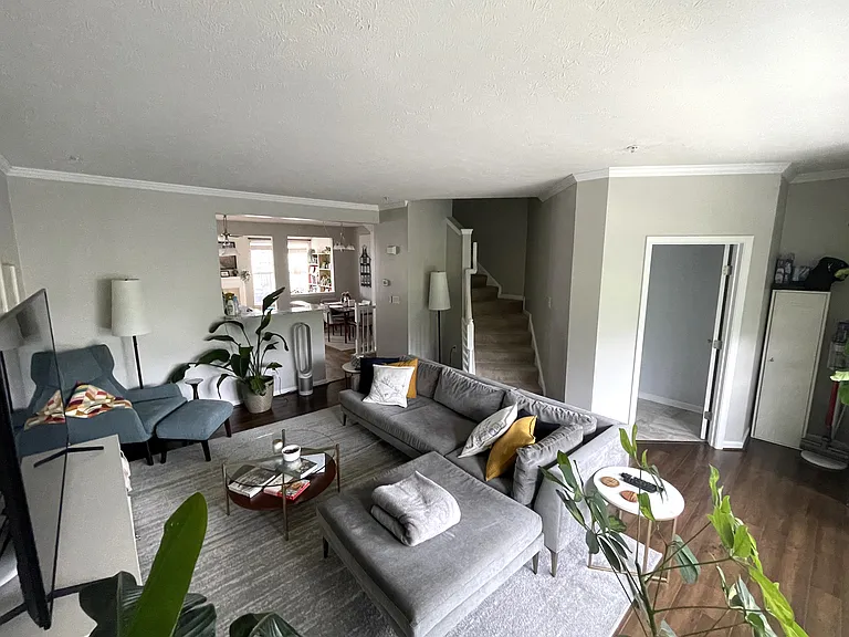 Family room facing towards kitchen, stairwell to third level and main level 1/2 bath