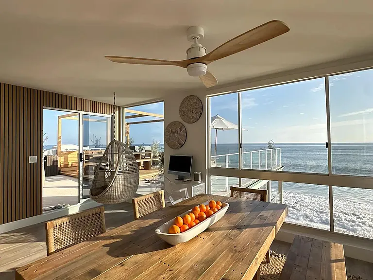 Gather indoors around the welcoming wooden table, fostering shared moments.