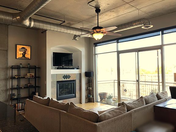Living room with gas fireplace and tv, floor to ceiling windows lead to the private balcony