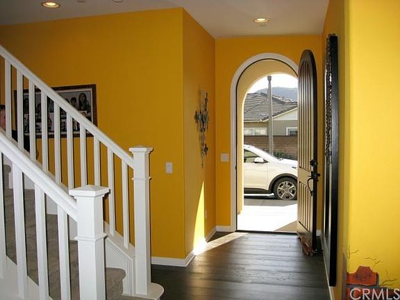 Elegant formal entry with a beautiful arched door and hardwood flooring.