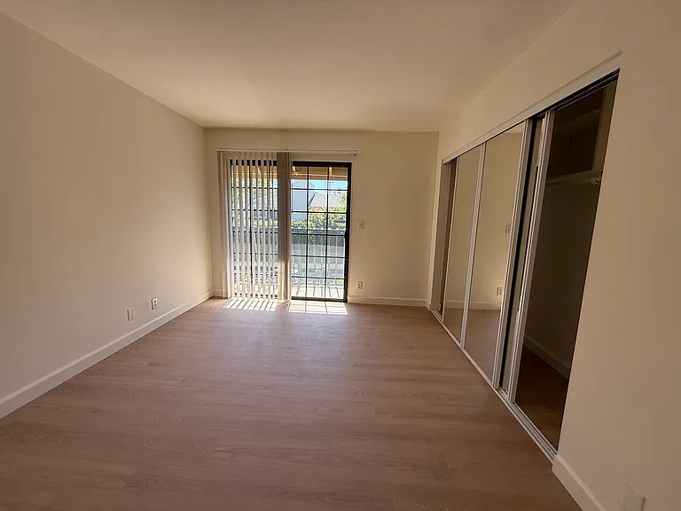 One bedroom with mirrored closet and balcony