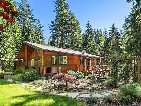Anther view of this welcoming home. Landscaping is deer-resistant and low-maintenance with in-ground irrigation. Path leads down western slope to the fire pit and forest glade and trails. Home was completely re-stained this year, including decks and railings.