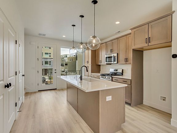 Kitchen with tan cabinets and center island in a sego home