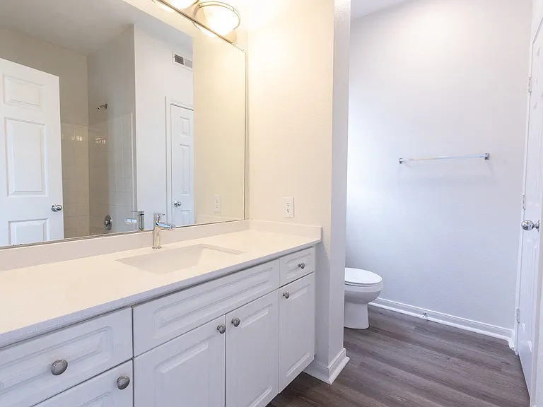 Spacious bathrooms feature modern finishes and large mirrors