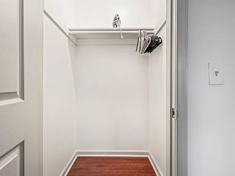 Walk-in closet with hanging rod and shelf, offering convenient storage for clothing and personal items.