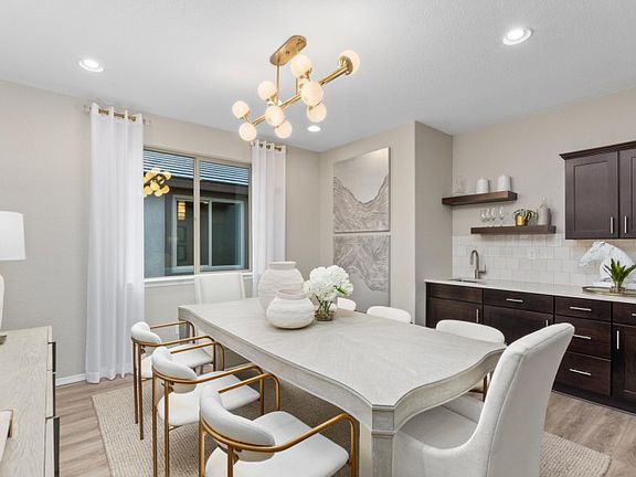 Dining room with decorative light, and a bar with extra cabinets for storage.