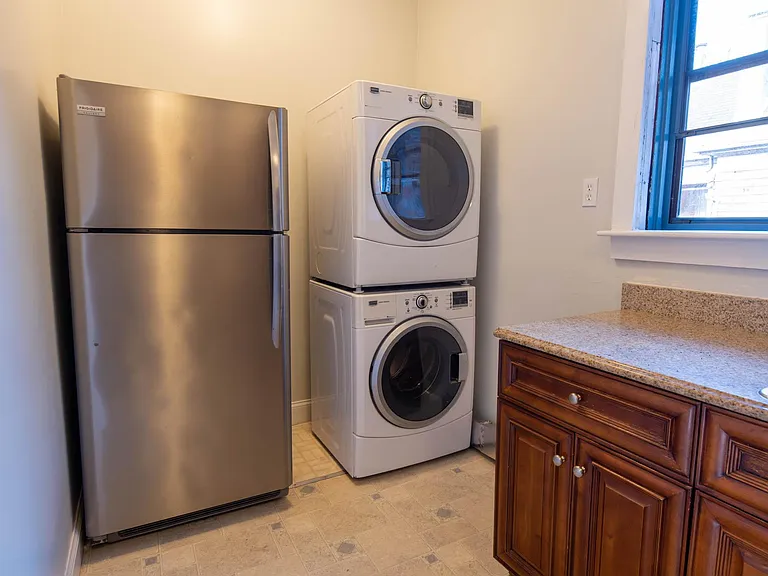 Kitchen, with stainless fridge and stacked washer and dryer