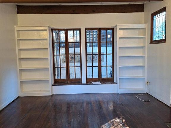 Another view of living room showing the bookcases and sunroom just beyond those two large windows.