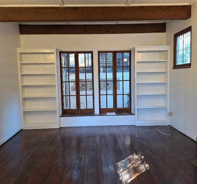 Another view of living room showing the bookcases and sunroom just beyond those two large windows.