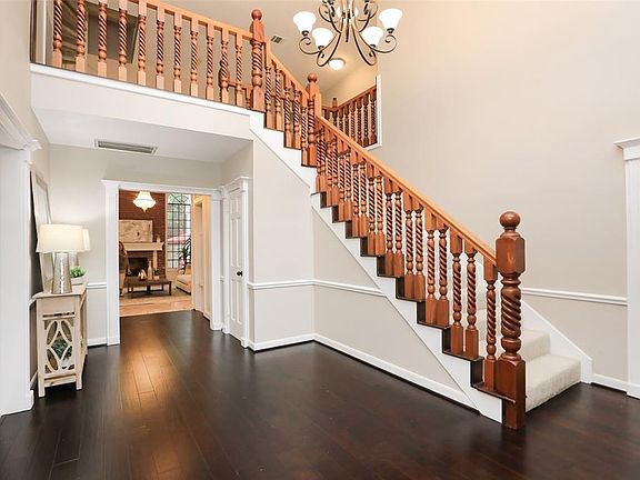 IMPRESSIVE ENTRY: The wide two-story foyer creates a welcoming entry for guests. Recent paint and new hardwood flooring provide fresh appeal. The custom designed mahogany balusters and newel post on the primary staircase are a work of art. You can se