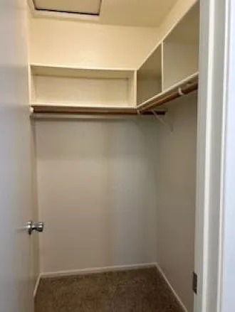 Master bedroom walk-in closet with fresh paint and storage cubbies