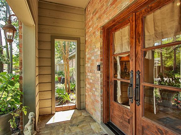 Slate decking and brick surround these eye-catching solid wood and wrought iron entry doors. Just wait until you see the inside! A decorator dreamscape!