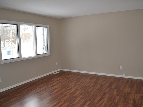 Main floor living room has more than enough space for a large sofa and TV. High quality Andersen windows give you a view to the front yard and the lake beyond.