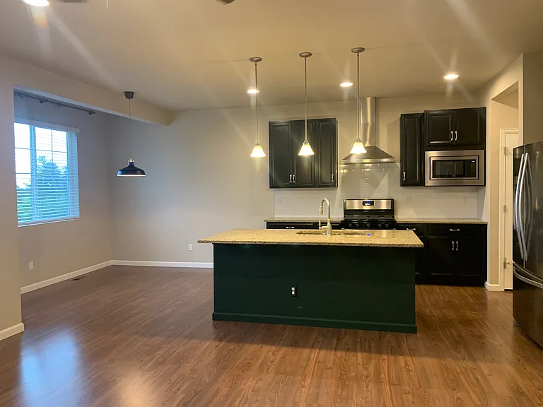 Kitchen - the island is no longer that dark color. Eating area that looks out on open space and the door to the deck.