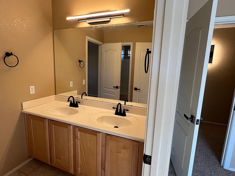 upstairs bathroom with dual sinks and two two holders and 3 hooks, medicine cabinet, lockable from both adjacent bedrooms, tub and shower and toilet accessible and lockable from sink room