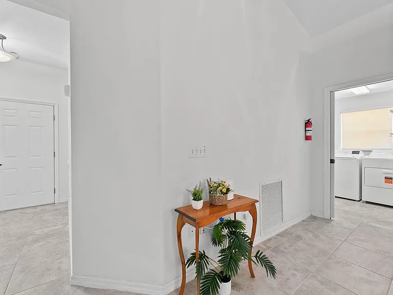 Entry hallway with tiled floors and a convenient laundry area featuring in-home washer and dryer.