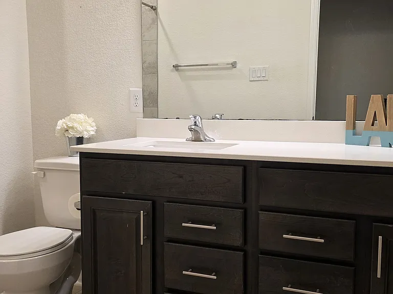 Second bathroom with oversized vanity and linen closet.