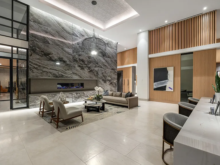 Luxurious lobby with modern marble accents, cozy seating area, stylish decor, and warm ambient lighting.