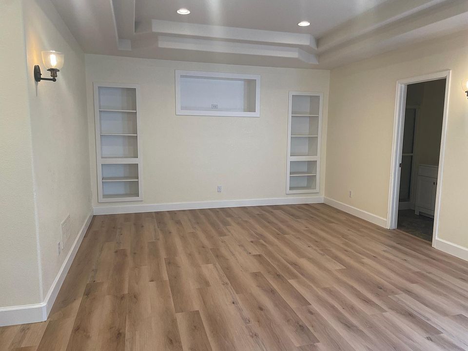 View of large open space in apartment. Bathroom is through the door on the right.