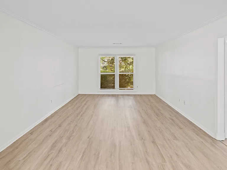 Sun-drenched bedroom with hardwood floors and garden views _ a peaceful, light-filled retreat.