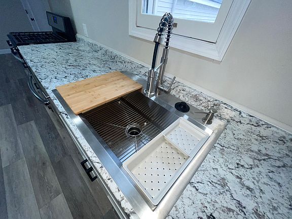 Oversized sink with built in cutting board and strainer