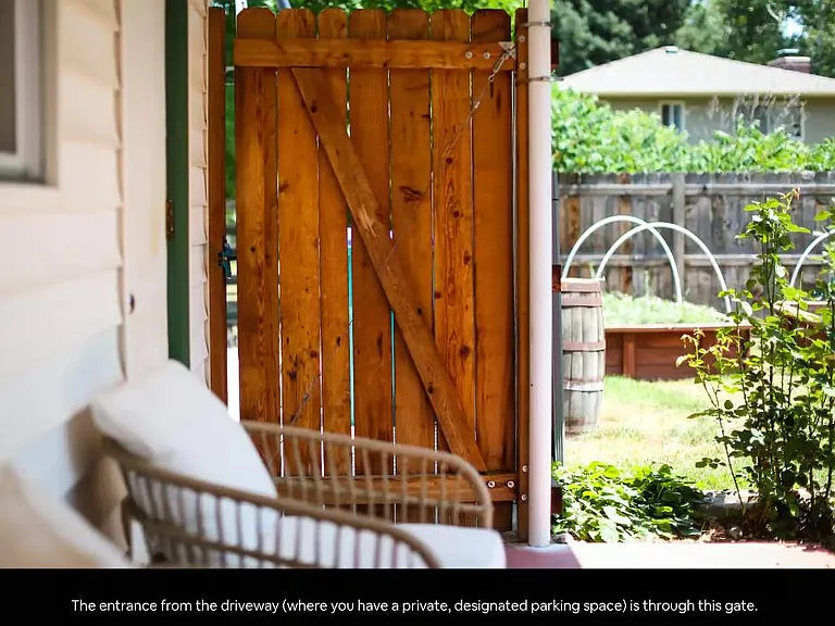 Backyard fence comes in from the driveway, next to the two car garage. Garden beds are available in the fenced in backyard. Seating area.