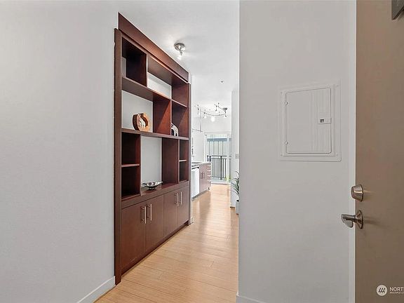 Entryway features built-in shelving and cabinets.