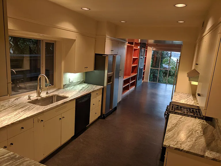 Kitchen has new(2021) window, refrigerator, gas stove, faucet, backsplash, and marble countertops. Barbeque gazebo visible in backyard has gas hook-up.
