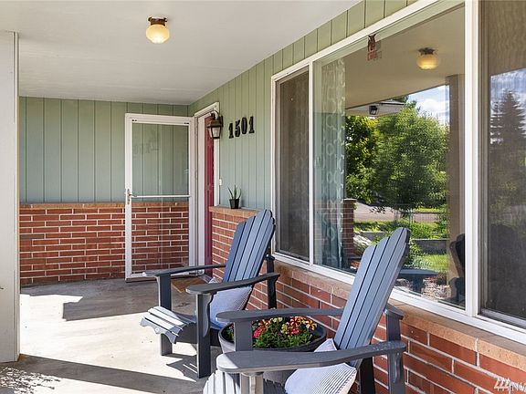 Concrete patio at entrance to home overlooks the front yard garden.