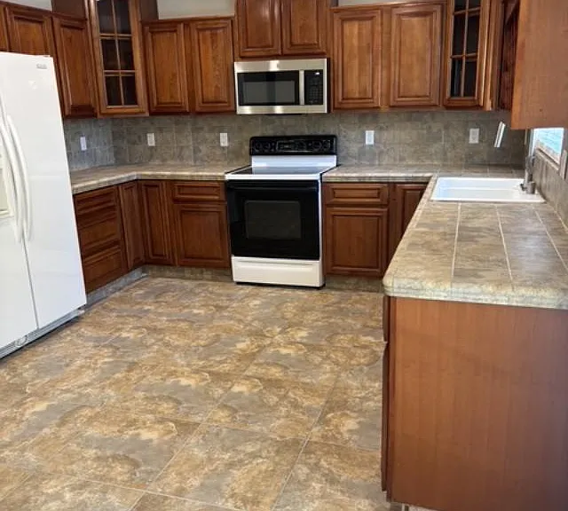 Immaculate spacious kitchen, fully equipped with lovely custom cherry cabinets, refrigerator, dishwasher, stove/oven, new microwave, tile floors and countertops.