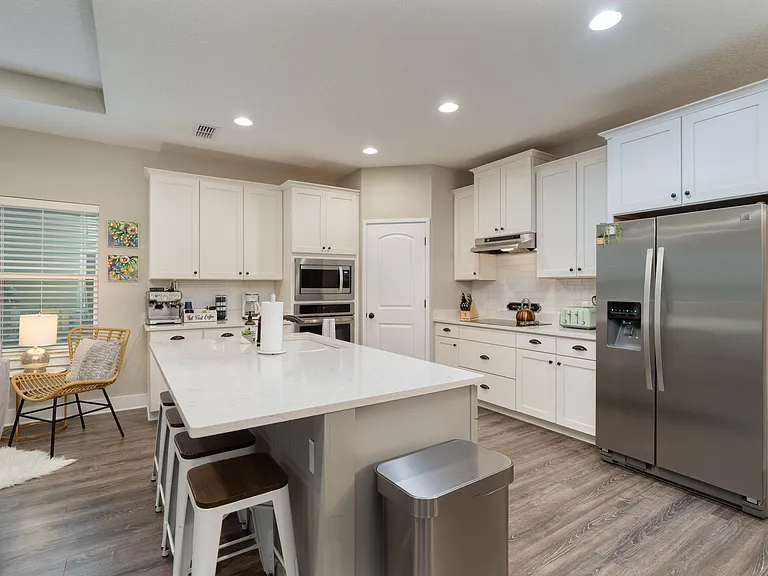 Crisp white cabinetry wraps around the entire space, offering an exceptionally clean look and plenty of room to store your group's favorite snacks