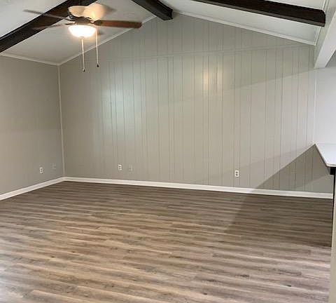 Living room with vaulted ceiling. Dining table and kitchen are just to the right.