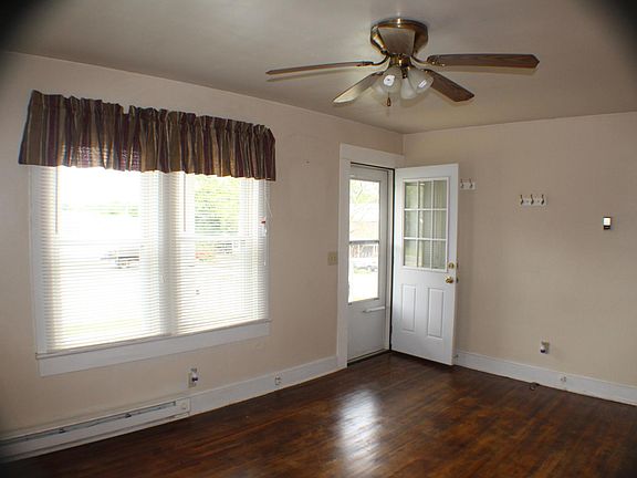 Large living room with hardwood floors and ceiling fan.


