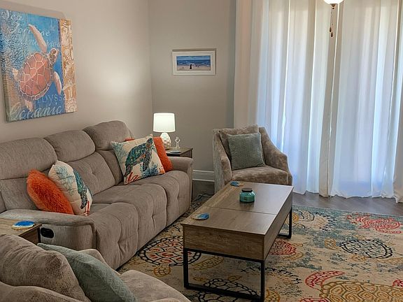 Living room with all new furniture, reclining sofa, swivel arm chairs, papasan chair with footrest (not shown). Coffee table has lift top converting it to a work station.