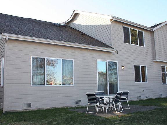 Patio overlooks level and fenced backyard.