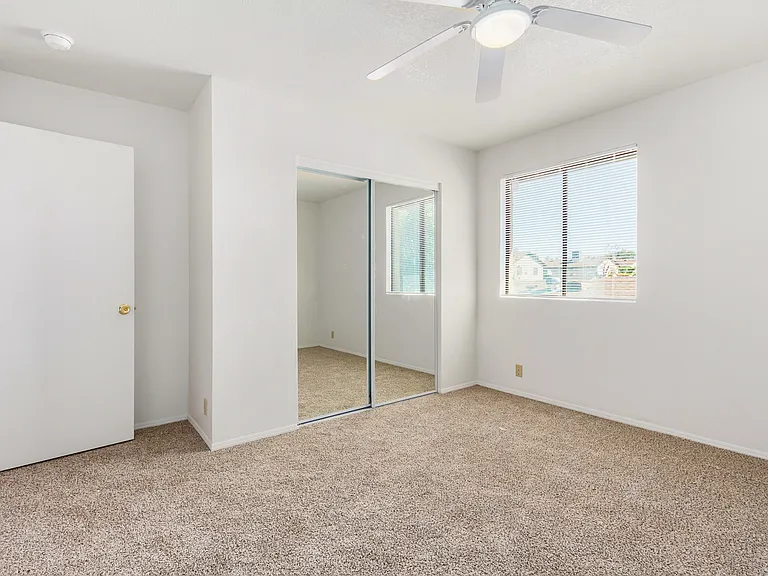 View of upstairs bedroom #2. New paint, flooring, and mirrored closet doors.